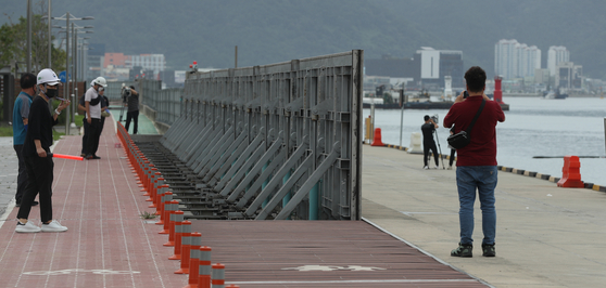 Workers install barrier walls near Masan Fish Market in Changwon, South Gyeongsang on Monday to prevent damage from Typhoon Hinnamnor. [YONHAP]