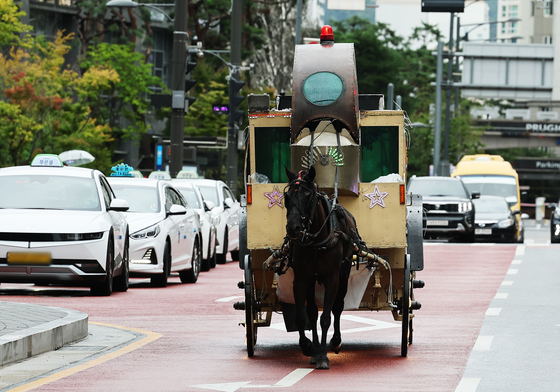 A horse-drawn carriage criticizing Kakao Games' Uma Musume Pretty Derby mobile game takes a spin around the Pangyo neighborhood in Gyeonggi, where Kakao Games is located, on Aug. 29. [YONHAP]