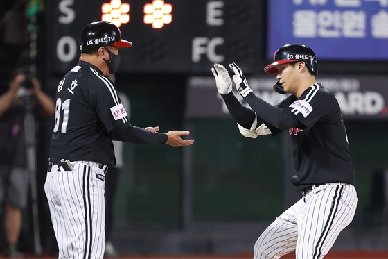 LG Twins infielder Moon Bo-gyeong celebrates with coach Kim Ho after hitting a solo home run at the the top of the eighth inning during a game against the KT Wiz at Suwon KT Wiz Park in Suwon, Gyeonggi on Friday. [YONHAP]
