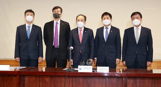 Finance Minister Choo Kyung-ho, middle, and Bank of Korea Gov. Rhee Chang-yong, second from left, at a meeting held in central Seoul to discuss the economy on Monday. [BOK]
