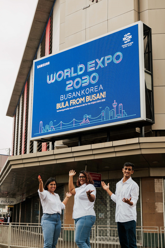 Models are before a Samsung Electronics advertising board promoting Busan as host city. [SAMSUNG ELECTRONICS] 