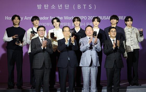 Prime Minister Han Duck-soo, second from left, front row, poses for a photo with K-pop boy band BTS, back row, during a ceremony to appoint the septet as promotional ambassadors for Busan's bid to host the 2030 World Expo at Hybe in Seoul on July 19. [YONHAP]