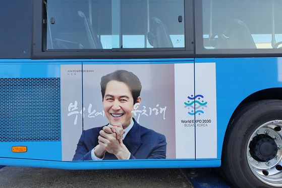 A poster of actor Lee Jung-jae, one of the promotional ambassadors for Busan's bidding activities for the World Expo 2030, on the side of a bus in Busan. The city government put up such posters on 450 buses in the city. [BUSAN METROPOLITAN GOVERNMENT]