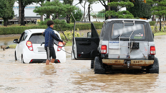 Koo Kang-min, a 28-year-old in Gyeongju, North Gyeongsang, rescues a car from a submerged road Tuesday. [NEWS1] 