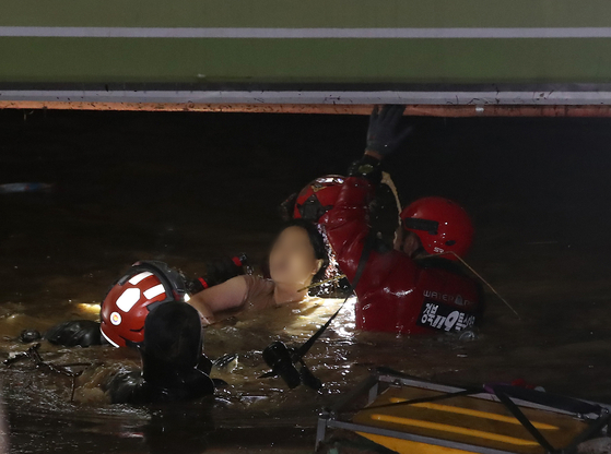 Rescuers pull a 52-year-old woman out from a flooded underground parking garage at an apartment complex in Pohang, North Gyeongsang on Tuesday night, more than 12 hours after she went missing in the aftermath of Typhoon Hinnamnor. Her teenage son was found dead in the same garage hours later. [NEWS1]