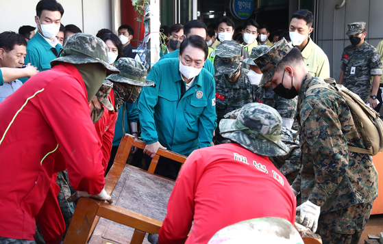 President Yoon Suk-yeol, center, helps move fallen furniture at Ocheon Market in Pohang, North Gyeongsang, amid typhoon recovery efforts on Wednesday. [JOINT PRESS CORPS]