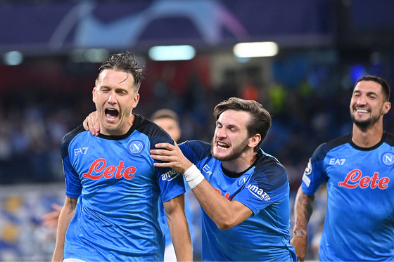 Napoli midfielder Piotr Zielinski, left, celebrates after scoring a penalty during a UEFA Champions League Group A match against Liverpool at Stadio Diego Armando Maradona in Naples on Wednesday. [AFP/YONHAP]
