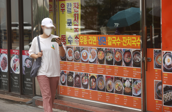 A person passes by a restaurant in Seoul on July 17. [YONHAP] 