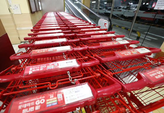 Shopping carts are lined up outside a large mart in Seoul on a closing day. [YONHAP]