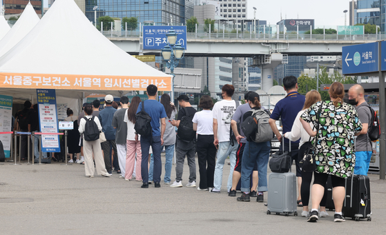 People wait to get tested for Covid-19 at a testing center in front of Seoul Station, central Seoul, on the final day of the four-day Chuseok harvest holiday on Monday. [YONHAP]