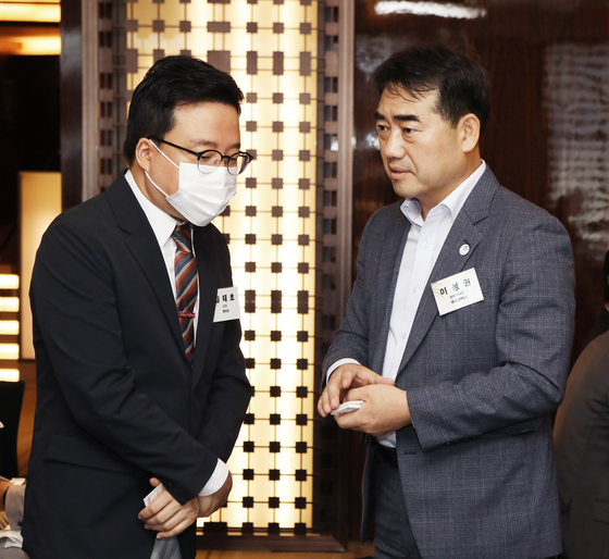 Kim Tae-ho, chief operating officer (COO) of HYBE (left), and Lee Seong-kweun, Busan vice mayor for economic affairs, exchange greetings during the forum. [PARK SANG-MOON]