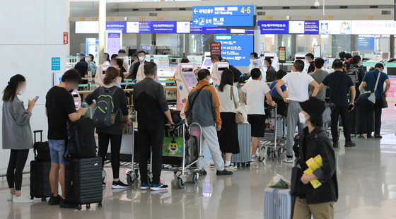 Tourists line up at Incheon International Airport on Tuesday. [NEWS1]