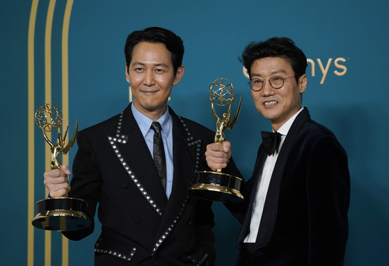 Lee Jung-jae, winner of the Emmy for Outstanding Lead Actor in a Drama Series for ″Squid Game,″ left, and Hwang Dong-hyuk, winner of the Emmy for Outstanding Directing for a Drama Series for ″Squid Game,″ pose for the photos with their trophies on hand at the 74th Primetime Emmy Awards on Monday at the Microsoft Theater in Los Angeles. [AP/YONHAP]