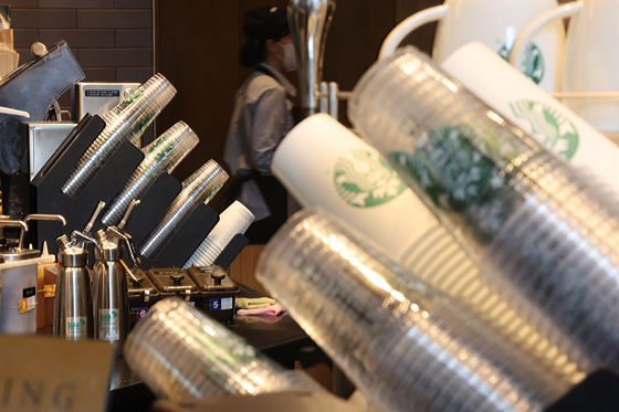 Disposable coffee cups are stacked up at a Starbucks in Seoul on Tuesday. According to data provided by the Environment Ministry to the office of People Power Party representative Lee Joo-hwan, disposable cups used at 14 coffee franchise and four fast food restaurants amounted to some 1 billion in 2021 — a significant increase from the average annual disposable cups of 780 million that had been used between 2017 and 2019. The annual average disposable cups that were used during the pandemic between 2020 and 2021 was 995.6 million. [YONHAP] 