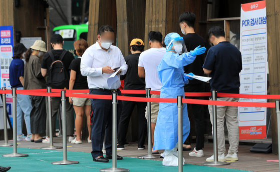 People wait in line to get tested for Covid-19 at a center in Songpa District, southern Seoul on Tuesday. [NEWS1]
