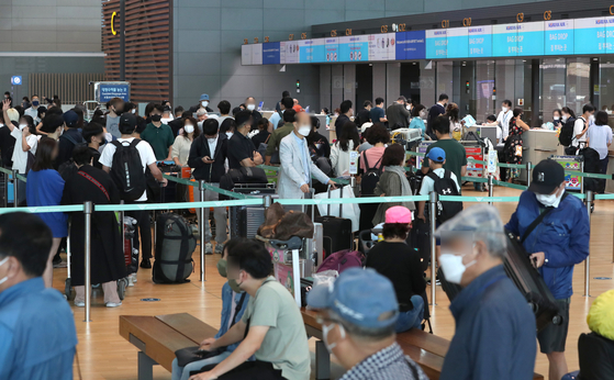 Travelers wait in line to check in their luggage for flights at Incheon International Airport Terminal 2 on Wednesday, as the demand for overseas travel has increased since the lifting of mandatory Covid-19 tests for entry. [NEWS1]