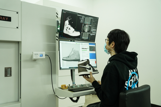 An employee examines a shoe at Naver Kream's inspection center. [NAVER KREAM]