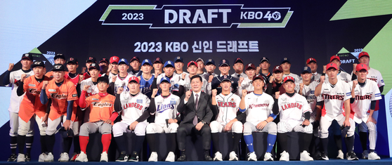 KBO Commissioner Heo Koo-youn, front row center, poses with the drafted players at the 2023 KBO Rookie Draft at the Westin Josun Hotel in central Seoul on Thursday. Seoul High School pitcher Kim Seo-hyeon was picked first by the Hanwha Eagles, but did not attend the draft as he is currently pitching for Korea at the U-18 Baseball World Cup in the United States. Second pick Yoon Young-cheol, a pitcher that went to the Kia Tigers, also missed the draft due to the ongoing World Cup.  [NEWS1]