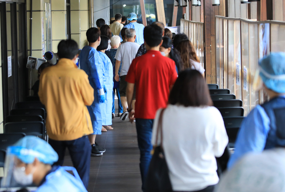 People wait in line to get tested for Covid-19 at Songpa District, southern Seoul, on Thursday. [NEWS1]