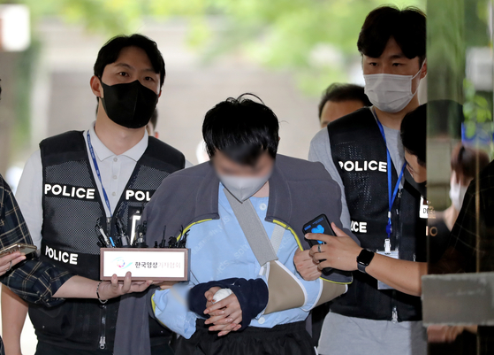 A 31-year-old man who faces charges of stalking and fatally stabbing his former female colleague arrives at the Seoul Central District Court on Friday for a trial on his pre-trial detention warrant. [NEWS1]