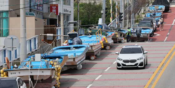Small fishing boats are stored on a hillside road in Haeundae District, Busan, to avoid being damaged as Typhoon Nanmadol, which is moving toward Japan, is expected to bring strong winds and heavy rainfall to southern coastal cities on Monday morning. [SONG BONG-GEUN]