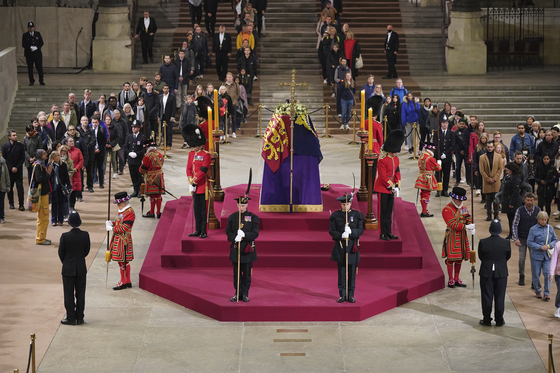 Members of the public pay their respects at the coffin of Queen Elizabeth II, lying in state in Westminster Hall at the Palace of Westminster in London early Monday, ahead of a state funeral to be held later that morning. [AP/YONHAP]