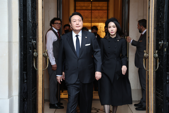 President Yoon Suk-yeol, left, and first lady Kim Keon-hee leave a hotel in London to attend the state funeral of Queen Elizabeth II Monday morning. [YONHAP]