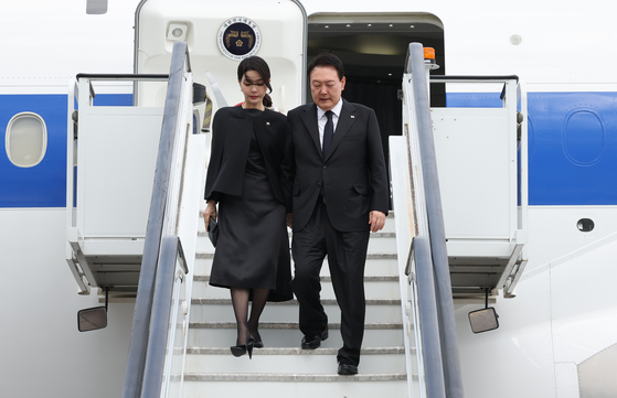 President Yoon Suk-yeol and first lady Kim Keon-hee disembark from the presidential plane after arriving at London Stansted Airport on Sunday. [YONHAP]
