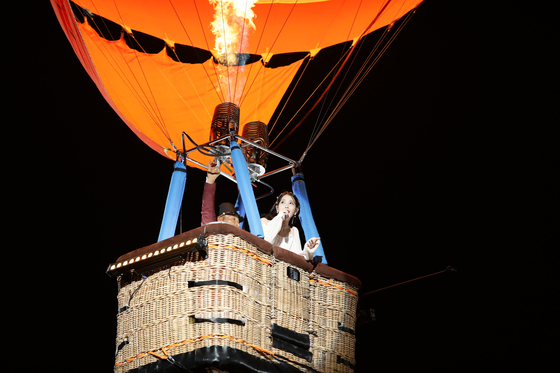 IU performs whlle circling the stadium in a hot air balloon during "The Golden Hour: Under the Orange Sun." [EDAM ENTERTAINMENT]