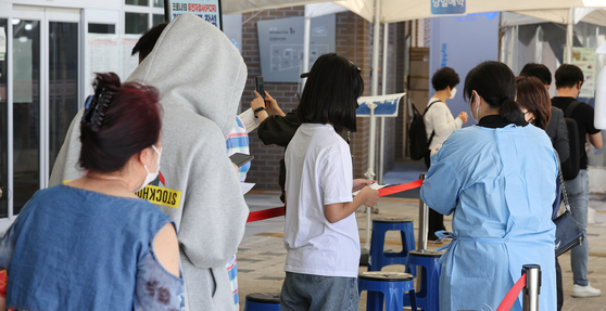 People wait in line to get tested for Covid-19 at a testing center in Mapo District, western Seoul, on Tuesday. [YONHAP]