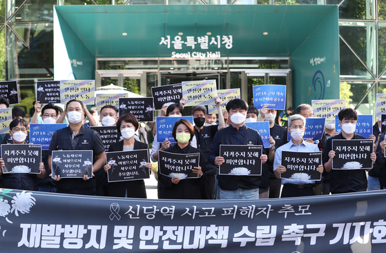 Members of the Seoul Metro labor union hold a press conference in front of Seoul City Hall on Tuesday to condemn the fatal stabbing of a co-worker and demand measures to prevent any future such tragedy. [YONHAP]