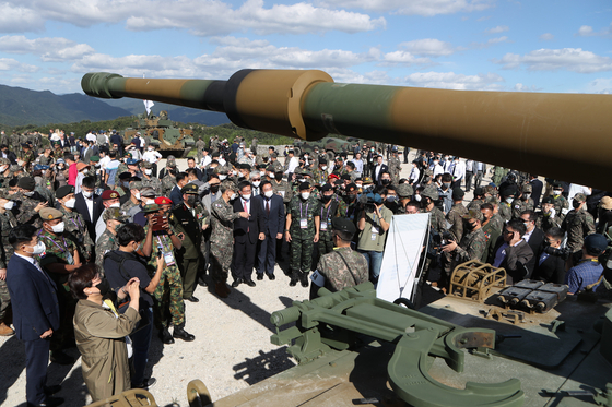 Military officials from foreign countries examine K9 howitzers on display during a demonstration at Defense Expo Korea 2022 held in a military training field in Pocheon, Gyeonggi, on Tuesday. [YONHAP]