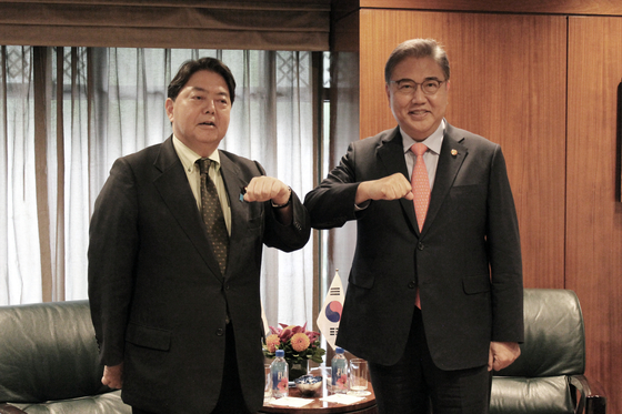 Foreign Minister Park Jin, right, and his Japanese counterpart, Yoshimasa Hayashi, bump elbows during a meeting at a hotel in New York on Monday. [JOINT PRESS CORPS]