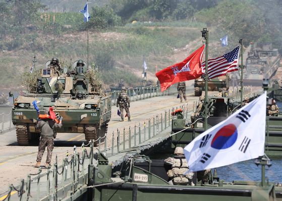 Armored vehicles of Korea-U.S. combined forces in a joint drill cross over a floating bridge on a river in Yeoju, Gyeonggi, on Wednesday. [YONHAP]