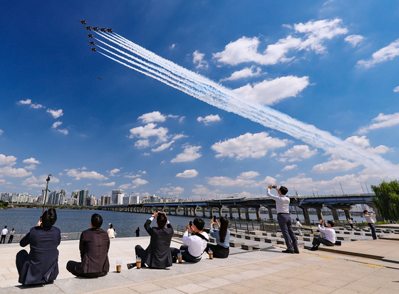 Spectators watch the Black Eagles, the Korean Air Force’s aerobatics team, rehearse over the Han River in Seoul on Wednesday. The Black Eagles will perform aerobatic maneuvers in celebration of the 74th Armed Forces Day on Oct. 1. [YONHAP]