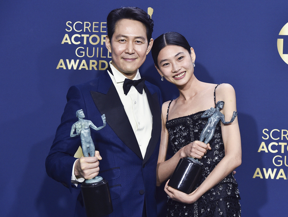 Lee Jung-jae, left, winner of the award for Outstanding Performance by a Male Actor in a Drama Series, and Jung Hoyeon, winner of the award for Outstanding Performance by a Female Actor in a Drama Series for Netflix’s dystopian hit “Squid Game” pose for a photo at this year’s annual Screen Actors Guild Awards on Feb. 27 in Santa Monica, California. [AP/YONHAP]