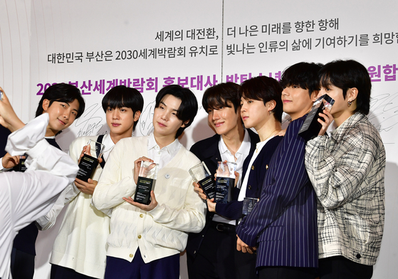 BTS members pose in front of cameras after being appointed as ambassadors for Busan’s bid to host the World Expo 2030 on July 18 at their agency HYBE in Yongsan District, central Seoul. [NEWS1]