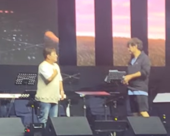 Huh Gak, left, and the intruder that snatched Huh's microphone away from him [SCREEN CAPTURE]