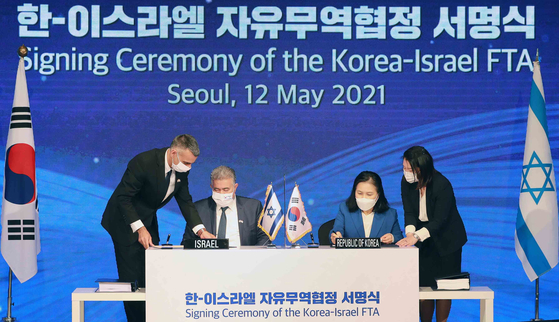 Yoo Myung-hee, drector general for FTA negotiation at Korea's Trade Ministry, right, and Amir Peretz, Israel's minister of economy, left, sign the Korea-Israel free trade agreement at Lotte Hotel Seoul on May 12, 2021. [NEWS] 