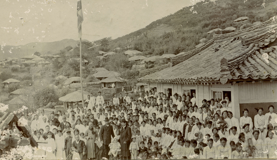 Australian missionaries, James Mackenzie and Andrew Adamson, standing with Koreans in front of Tongyeong Mission which is still in place, in this photo dated 1901. [KYONGGI UNIVERSITY SOSUNG MUSEUM] 