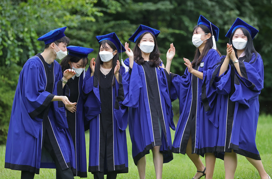 New graduates of Seoul National University pose for photos at Gwanak Campus on Aug. 27, 2021. [YONHAP]