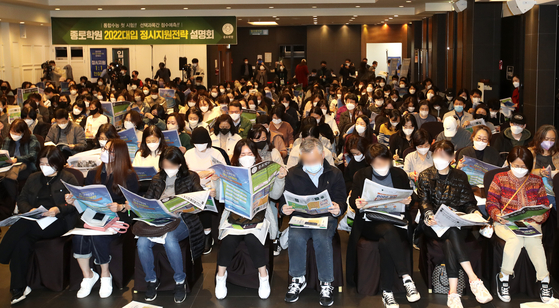Parents read through information packets at a college admissions presentation hosted by Jongno Academy at Konkuk University Alumni Hall in Gwangjin District, eastern Seoul, on Nov. 19, 2021. [JANG JIN-YOUNG]