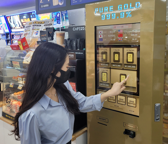 A woman uses a gold bar vending machine at a GS25 convenience store. GS Retail on Tuesday announced that it will be operating gold bar vending machines at five locations including GS convenience stores and its supermarket GS Fresh temporarily until August next year. [GS RETAIL] 