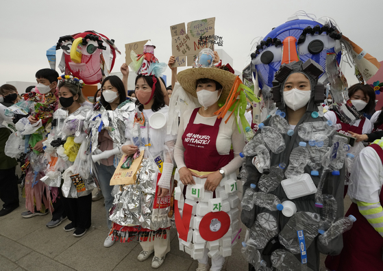 Environmental activists wearing outfits made from plastic waste participate in a campaign to mark Earth Day against climate change in Seoul,on April 22. [AP/YONHAP]