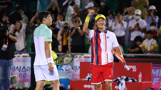Chung Hyeon, left, and Kwon Soon-woo react after winning their round of 16 game against Hans Hach Verdugo and Treat Huey at the Korea Open on center court of the Olympic Park Tennis Center in southern Seoul on Wednesday.  [YONHAP]
