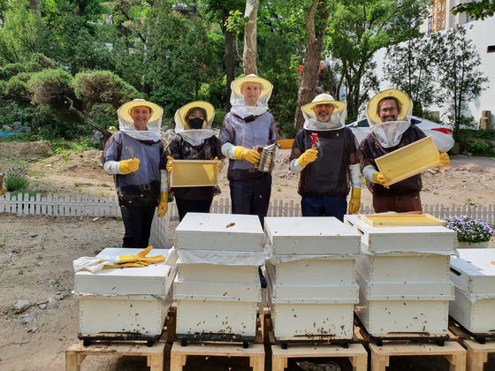 Members of the French Embassy in Seoul working with bees on May 11 at the French diplomatic residence in Seoul. [EMBASSY OF FRANCE IN KOREA]