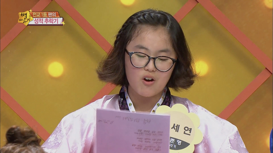 Sixteen-year-old Oh appears on TV wearing hanbok (traditional Korean dress) to recite her love letter to Jung. [AUD]