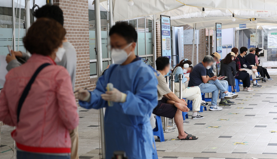 People line up to get tested for Covid-19 at a testing center in Mapo District, western Seoul, on Wednesday. [YONHAP]