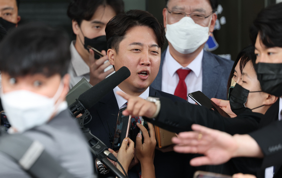 People Power Party former chairman Lee Jun-seok answers reporters' questions in front of the Seoul Southern District Court in Yangcheon District, southern Seoul, on Wednesday. [YONHAP]