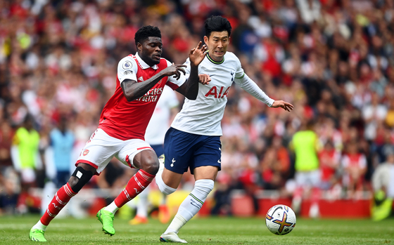 Arsenal's Thomas Partey, left, and Tottenham's Son Heung-min in action during a Premier League match in London on Saturday.  [EPA/YONHAP]